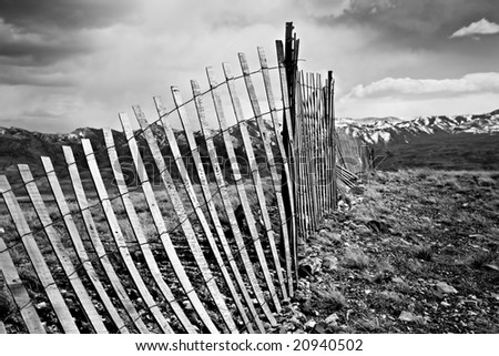 old broken fence running through the mountain countryside in Wyoming