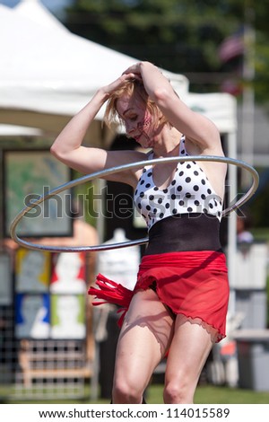 SUWANEE, GA - MAY 19:  A circus performer does the hula hoop, performing at the Arts In The Park spring festival on May 19, 2012 in Suwanee, GA. The performer is part of The Imperial OPA Circus.