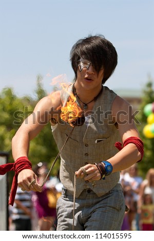 SUWANEE, GA - MAY 19:  A circus performer slings balls of fire while performing at Arts In The Park, a festival held on May 19, 2012 in Suwanee, GA.  The performer represents The Imperial OPA Circus.