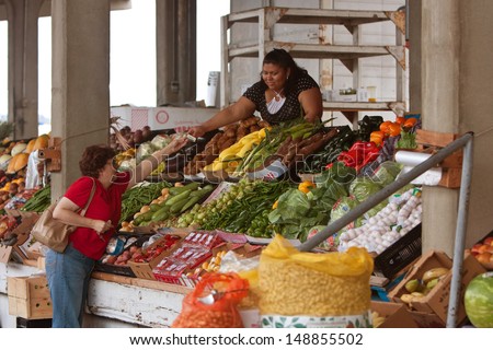 FOREST PARK, GA - JULY 27:  A female customer buys fresh produce at the Atlanta Farmers Market during the Georgia Grown Farmers Showcase on July 27, 2013 in Forest Park, GA.