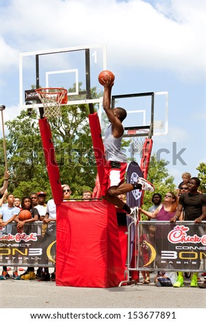 ATHENS, GA - AUGUST 24:  A young man elevates above the rim to dunk a basketball in the slam dunk competition of a 3-on-3 basketball tournament held on August 24, 2013 in Athens, GA.