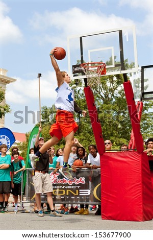 ATHENS, GA - AUGUST 24:  A young man elevates above the rim to dunk a basketball in the slam dunk competition of a 3-on-3 basketball tournament on August 24, 2013 in Athens, GA.