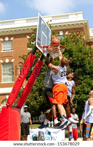 ATHENS, GA - AUGUST 24: Three men fight for the ball above the rim, in a 3-on-3 basketball tournament held on the streets of downtown Athens, on August 24, 2013 in Athens, GA.