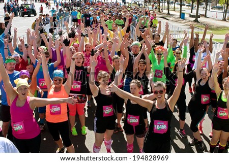 ATLANTA, GA - APRIL 5:  A throng of excited runners gathered at start line, jubilantly waves to camera at the Ridiculous Obstacle Challenge (ROC) 5k race, on April 5, 2014 in Atlanta, GA.