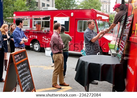 ATLANTA, GA - OCTOBER 16:  Customers stand in line to order meals from a popular food truck during their lunch hour, at \