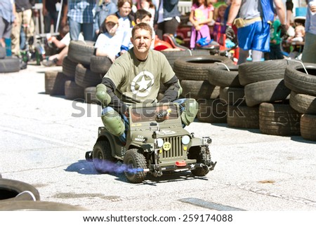 DECATUR, GA - OCTOBER 4:  A man drives a miniature army jeep in the power racing series at the annual Maker Faire Atlanta, on October 4, 2014 in Decatur, GA.