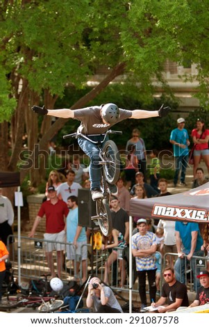 ATHENS, GA - APRIL 25:  Young BMX pro lets go of handlebars while performing a trick in the pro BMX competition at the annual Athens Twilight Criterium, on April 25, 2015 in Athens, GA.