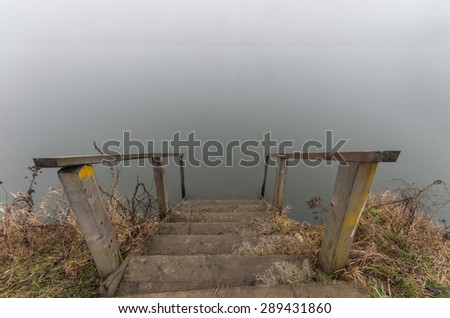 Stairs to the water, Vistula river bank in Krakow, Poland in heavy fog