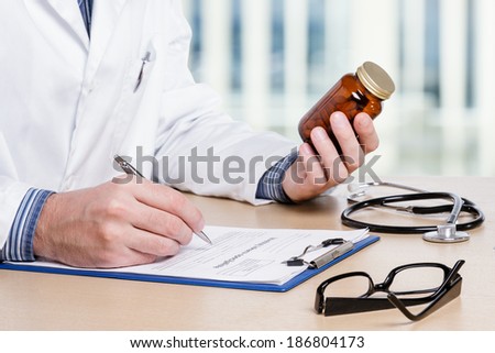 Doctor writing prescription at office.