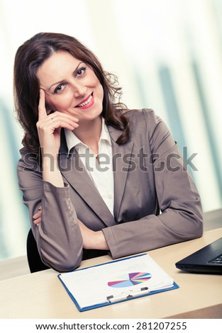 Middle-age business woman working in office. Portrait of smiling business woman. Toned photo