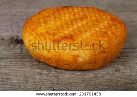 head hard cheese with paprika on an old wooden table