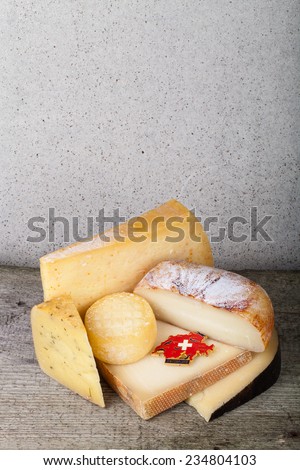 Head and various pieces of cheese on a wooden table