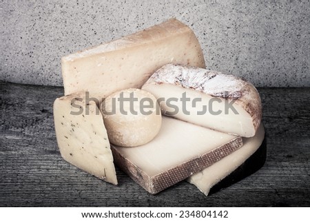 Head and various pieces of cheese on a wooden table.tinted