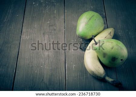 pears, bananas on an old wooden table background.tinted