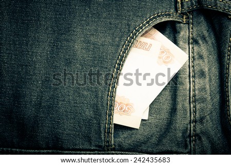 The pocket of jeans with money. Cloth background. Toned.