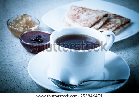Cup of tea with two kinds of jam and russian pancakes - blini. Toned.