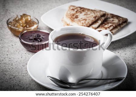 Cup of tea with two kinds of jam and russian pancakes - blini. Toned.