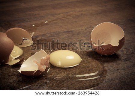 Broken eggs on the wooden floor. Toned.