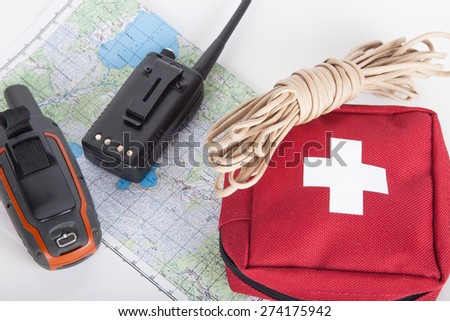 Map, gps navigator, portable radio, rope and first aid kit on a light background. Set lifeguard