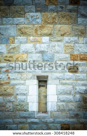 window in an old stone wall of a round tower. Europe, the Middle Ages. Background.