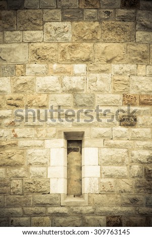 window in an old stone wall of a round tower. Europe, the Middle Ages. Background.Tinted
