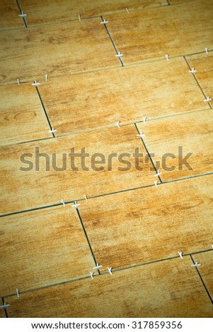 Laying ceramic tiles on a special cement grout. Selective focus. Shallow depth of field. Toned.