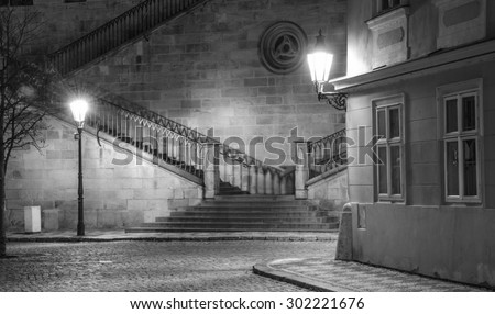 Old, ancient city in the night, two shining lantern, stairs in background, black and white (Prague, Kampa, Charles Bridge)