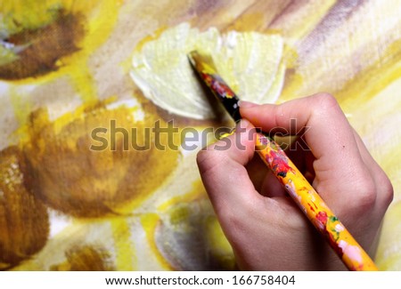 ArtistÃ?Â¢??s hand with paintbrush painting the picture