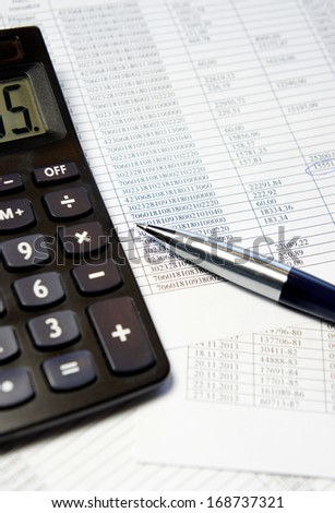 Calculator, pen and accounting document with a lot of numbers