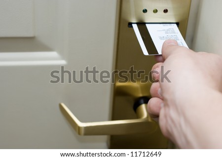 Hand inserting a keycard into a hotel electronic hotel door lock