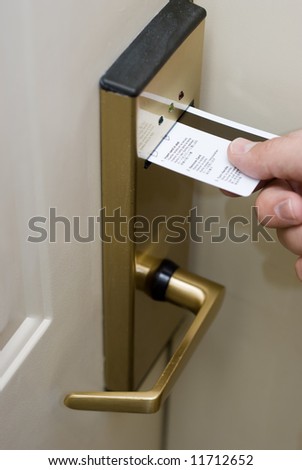 Hand inserting a keycard into a hotel electronic hotel door lock
