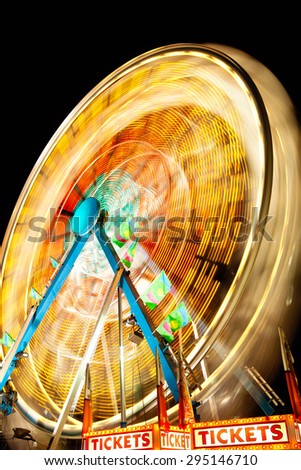 Picture of Carnival Ferris Wheel at night spinning motion blurred.