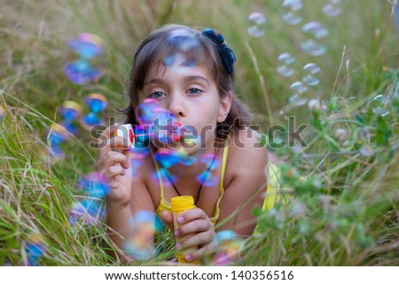Child and soap bubbles Description: Little girl having fun with soap bubbles