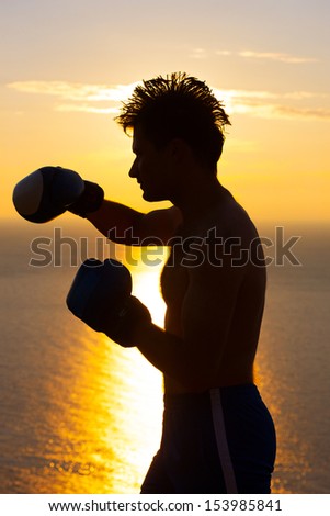 Silhouette of the boxer on background sunrise