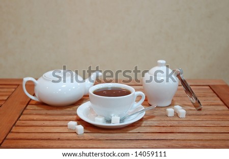 Cup of English tea, with tea service on an oak wood table