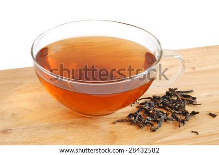 Glass cup with tea on wooden background