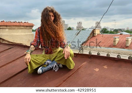 Young girl sitting on a iron roof