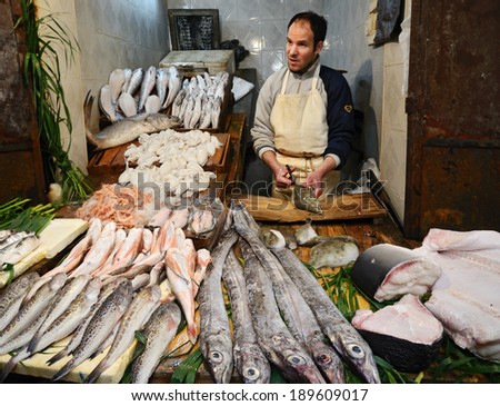 Fez, Morocco - March 5, 2014: Portrait of men selling fishes and seafood in a street market in Fez, Morocco