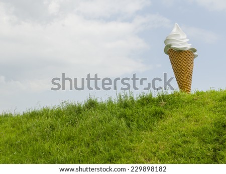 VOLENDAM, NETHERLANDS - May 19, 2012: Big artificial ice cream as a sign and promotion on a dike with grass.