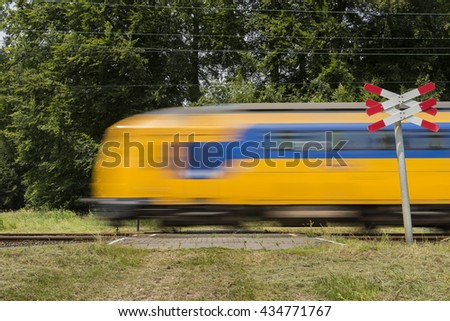 Similar – Image, Stock Photo A train passes a closed level crossing, houses are reflected in its windows / motion blur / travelling / rail traffic