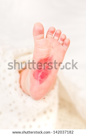 Feet of a newborn baby with a kiss