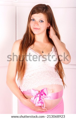 pregnancy, motherhood and happiness concept - happy pregnant woman and touching her belly