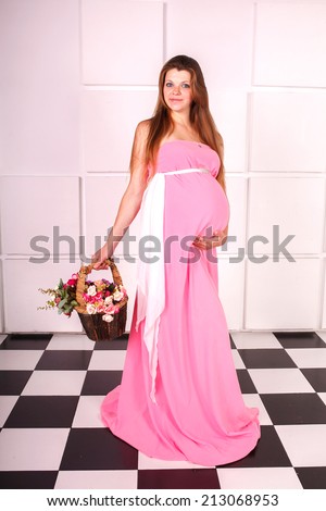pregnancy, motherhood and happiness concept - happy pregnant woman and touching her belly