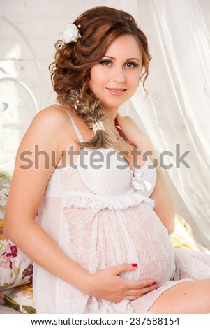 happy pregnant woman stroking in her big belly