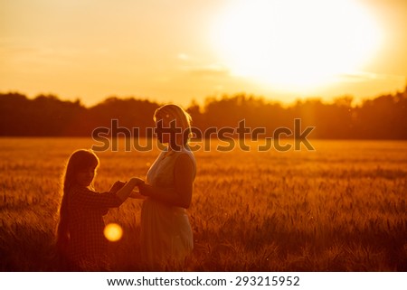 Young happy beautiful mother and her daughter . Happy family jumping together in a circle having fun and expressing emotions of joy, freedom, success. Silhouettes on sunny sky