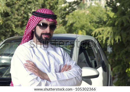 arabian guy posing against his car at home
