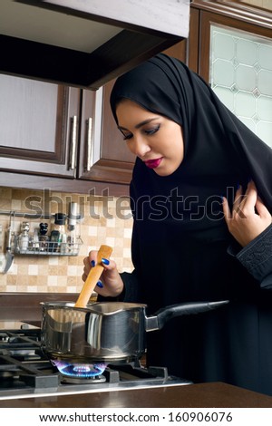 Arabian woman stirring food in the casserole
