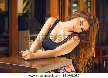 A beautiful model posing in an outdoor coffee shop