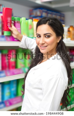 young woman holding bottle of shampoo in supermarket