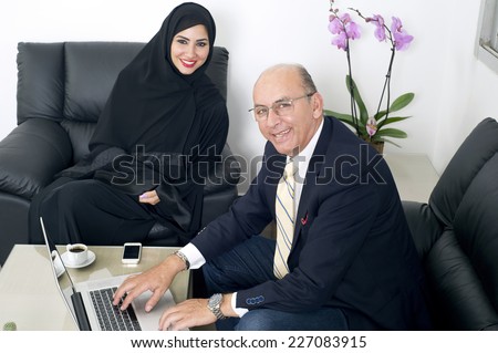 Multiracial Business meeting between a Senior Businessman & a woman wearing Hijab
